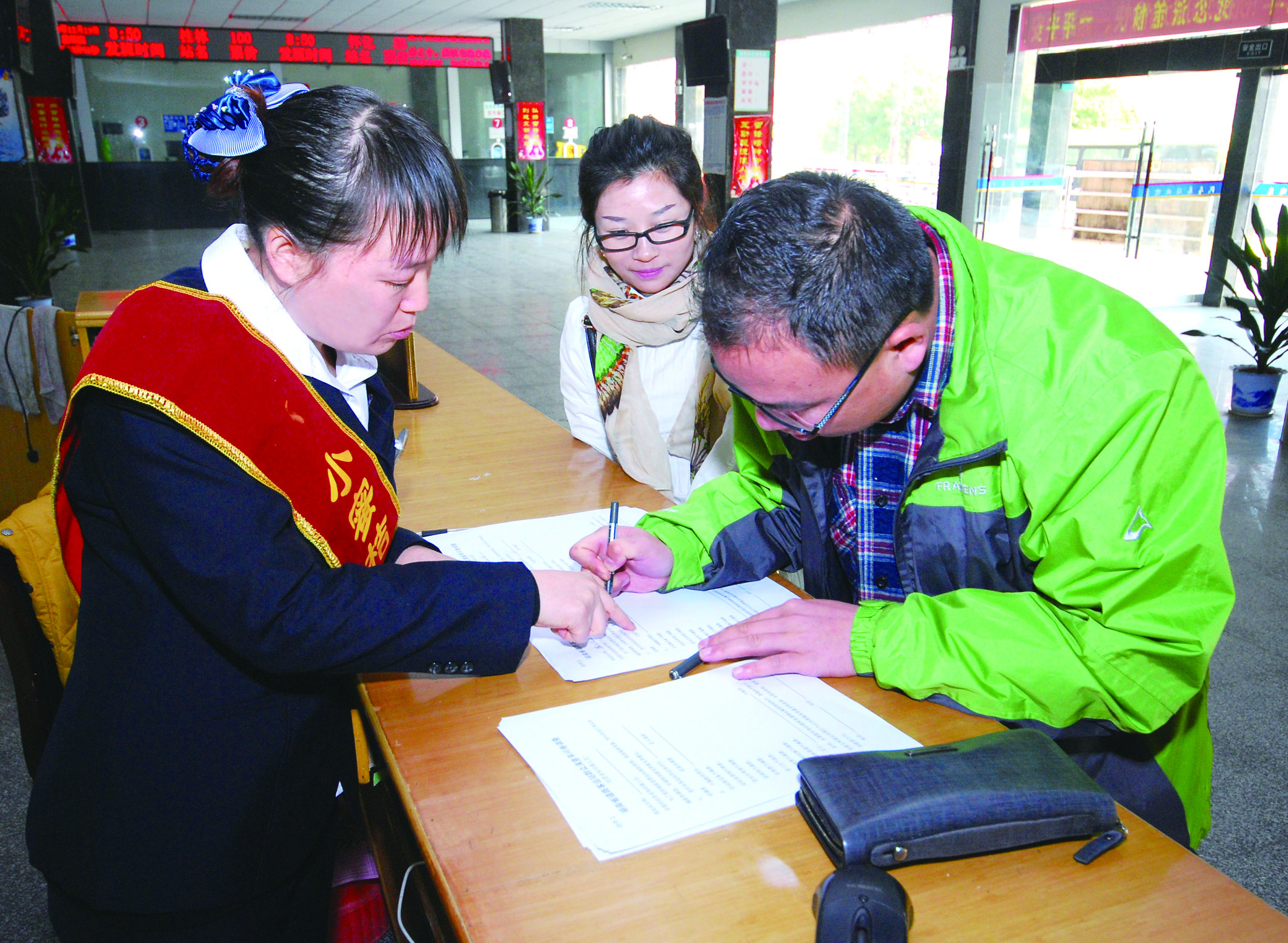 圖為洞口汽車總站站務人員在熱心為旅客服務。